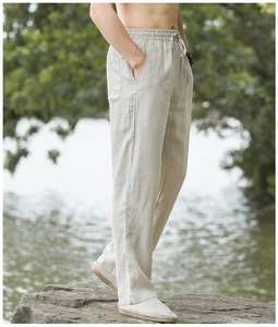 Detail of light beige linen pants showing elastic drawstring waist and premium texture