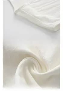 Dettaglio della trama in lino bianco e delle cuciture sulle spalle del gilet cinese