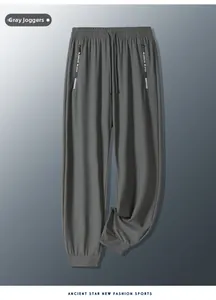 Detail view of dark grey ice silk sports pants with zippered pockets and drawstring waist