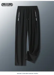 Detailed view of elastic waistband with drawstring and branded zipper pocket on black pants