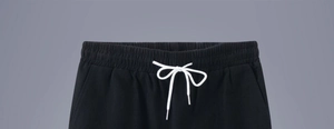 Detail of black cotton linen shorts with elastic waist and white adjustable drawstrings