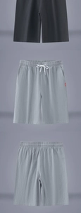 Detailed macro view of linen shorts showing elastic waistband, drawstrings, and fabric texture