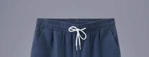 Detail view of elastic waistband with white drawstring on linen casual shorts for men