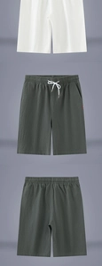 Detail of white and green linen shorts with elastic drawstring waist and side red label