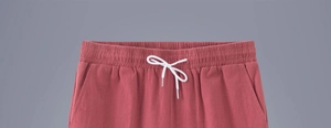 Detail view of cotton linen shorts with elastic waist and white drawstring design