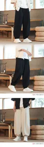 Dettaglio dei pantaloni ampi in misto lino nero e bianco sporco in stile Zen