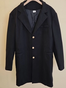 Détails du manteau en laine noir pour hommes avec boutons dorés et revers cranté