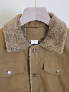 Detailed close-up of brown work jacket showing fleece collar and engraved metal buttons