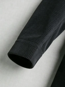 Gros plan sur la texture en velours côtelé noir de la manche d'un blazer pour hommes