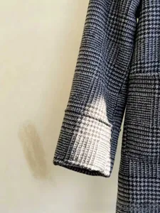 Detail of the houndstooth pattern fabric and cuff stitching on this grey casual jacket