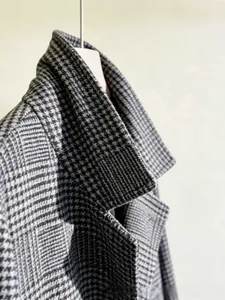 Close-up of the notch lapel on a black and white houndstooth wool coat for men