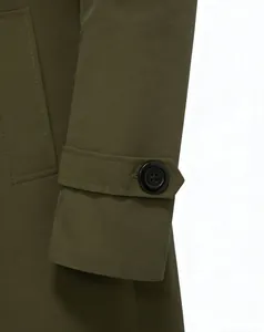 Detailed macro view of olive green trench coat cuff strap with dark four-hole button