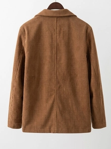Macro detail of brown corduroy blazer showing premium texture and back stitching