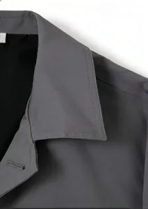 Close-up of the dark grey trench coat neckline and shoulder with fine twill texture