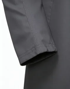Detailed macro view of the dark grey trench coat cuff with neat double-needle stitching