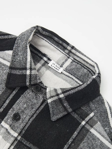 Close-up of black and white plaid flannel shirt collar with size tag and buttons