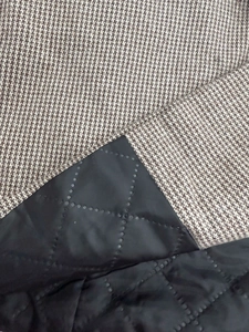 Gros plan du tissu pied-de-poule marron avec doublure matelassée en losanges pour la chaleur