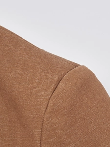 Detail of premium brown suit fabric showing refined grain texture and precise stitching