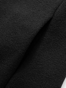 Close-up texture of black wool blend fabric on a men's business casual winter trench coat