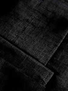 Macro shot of black textured woven fabric showing precise stitching and material detail