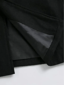 Close-up of the black woolen coat featuring a back vent slit and smooth inner lining