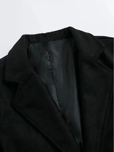 Detail close-up of classic notch lapel and fine stitching on a black trench coat