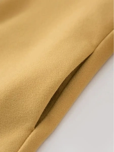 Macro shot of side pocket stitching on a camel wool blend mid-length trench coat