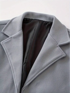 Close-up of the notch lapel and thick woven texture on a grey wool blend coat