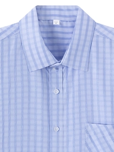 Close-up of the light blue plaid shirt featuring a button-down front and chest pocket detail