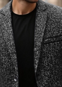 Close-up of lapel and tweed texture on men's casual blazer with metallic button
