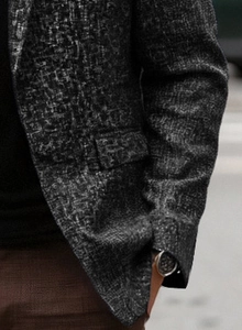 Detailed close-up of dark grey textured fabric on a men's casual tailored blazer jacket