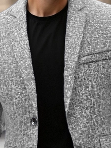 Close-up of grey textured blazer fabric with single-breasted notch lapel and fine weave