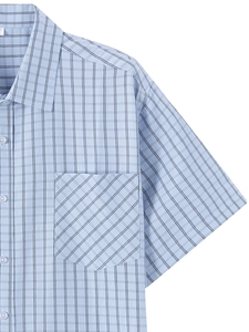 Detail of light blue plaid shirt pocket with diagonal pattern and button-down collar
