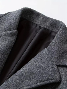 Detailed view of dark grey wool coat collar with premium smooth black inner lining