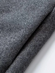 Macro texture of dark grey wool blend fabric showing thick fibers on a winter overcoat