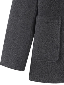 Detail shot of a dark grey wool coat showing the textured fabric and large side patch pocket