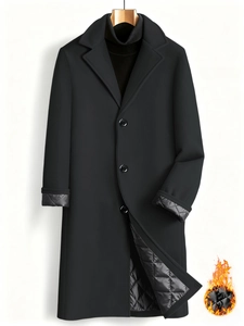 Detail view of the quilted diamond-pattern lining on a black long wool coat for men
