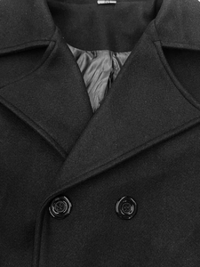 Dettaglio del cappotto doppiopetto in misto lana con revers e etichetta taglia M