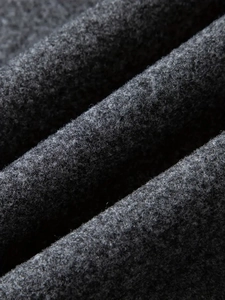 Macro shot of charcoal grey wool fabric texture showing the thick brushed winter material