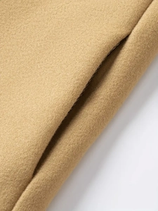 Detailed view of the camel wool blend fabric and precision stitching on the jacket pocket