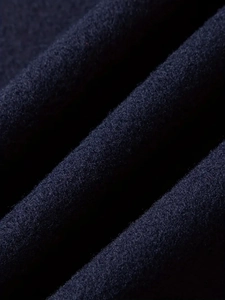 Dettaglio ravvicinato del tessuto di lana blu scuro con trama spessa e fibre calde