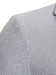 Dettaglio della trama in lana grigia e cuciture sulle spalle di questo cappotto da uomo