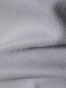 Dettaglio macro del tessuto di lana grigio che mostra la superficie spazzolata e il materiale