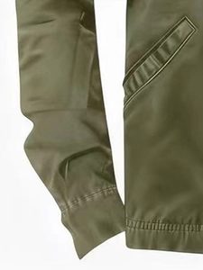 Detail of army green winter jacket featuring ribbed cuffs and diagonal pockets
