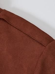 Detail of dark brown faux suede fabric with precise double-row stitching on jacket
