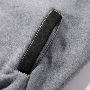 Detail view of heather grey knit jacket with black ribbed contrast trim on pocket edge