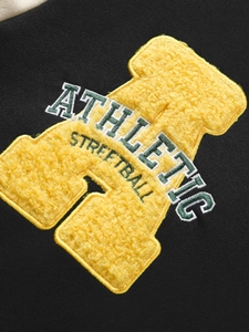 Detail of yellow chenille athletic streetball embroidery on black long sleeve hoodie