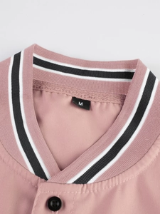 Detalle de chaqueta deportiva rosa con cuello acanalado de rayas blancas y negras
