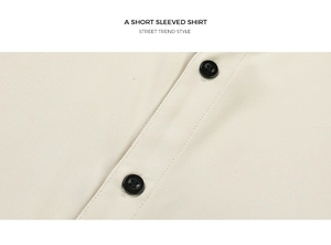 Gros plan d'une chemise beige à manches courtes, texture sergée et boutons noirs