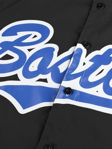 Primer plano del estampado artístico de letras azules y blancas en una camisa negra de manga corta